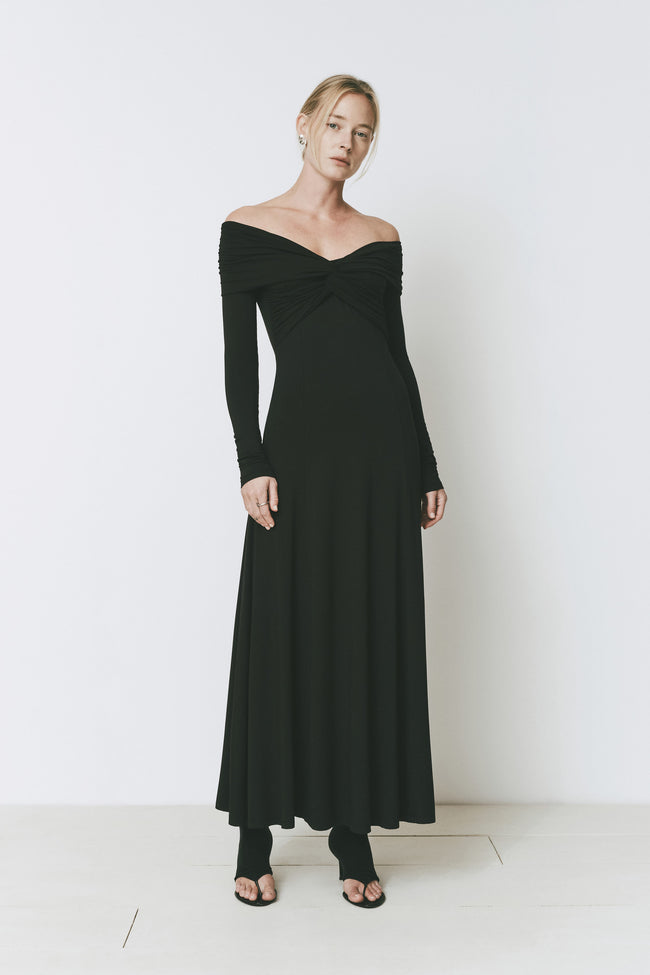 Elegant black Giverny Dress with off-the-shoulder neckline, twisted bust, long sleeves, and maxi length.