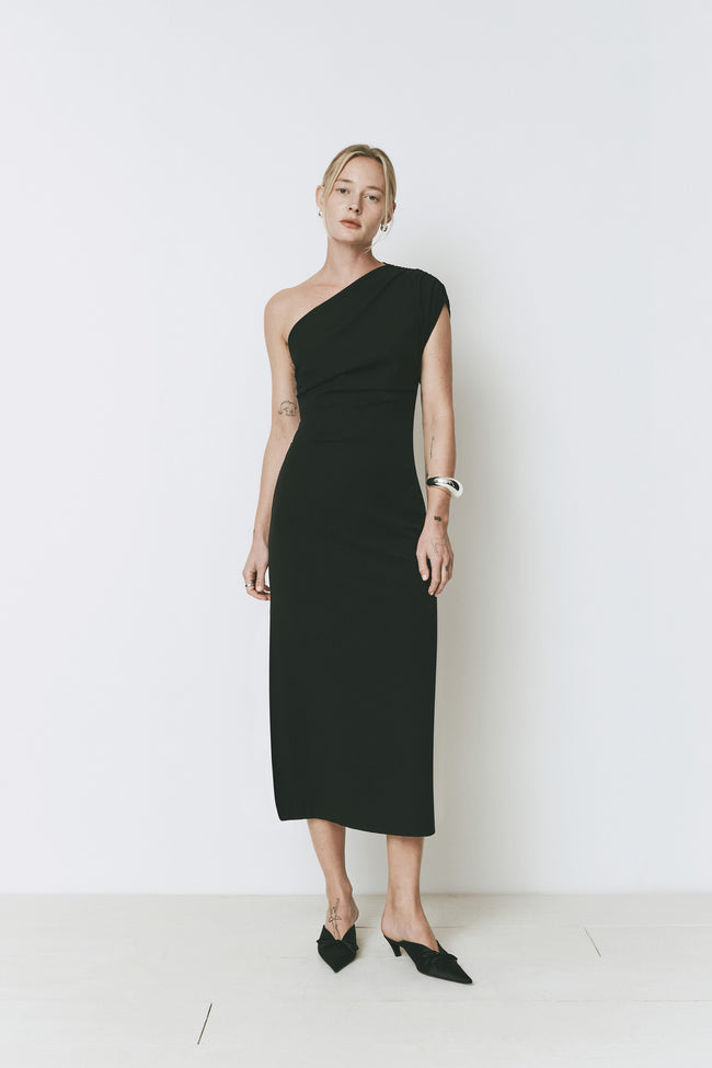 Black Palais dress with one shoulder, midi length, and leg slit.