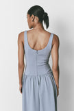 Light blue midi dress with drop waist, square neckline, smooth fabric, and back zipper detail