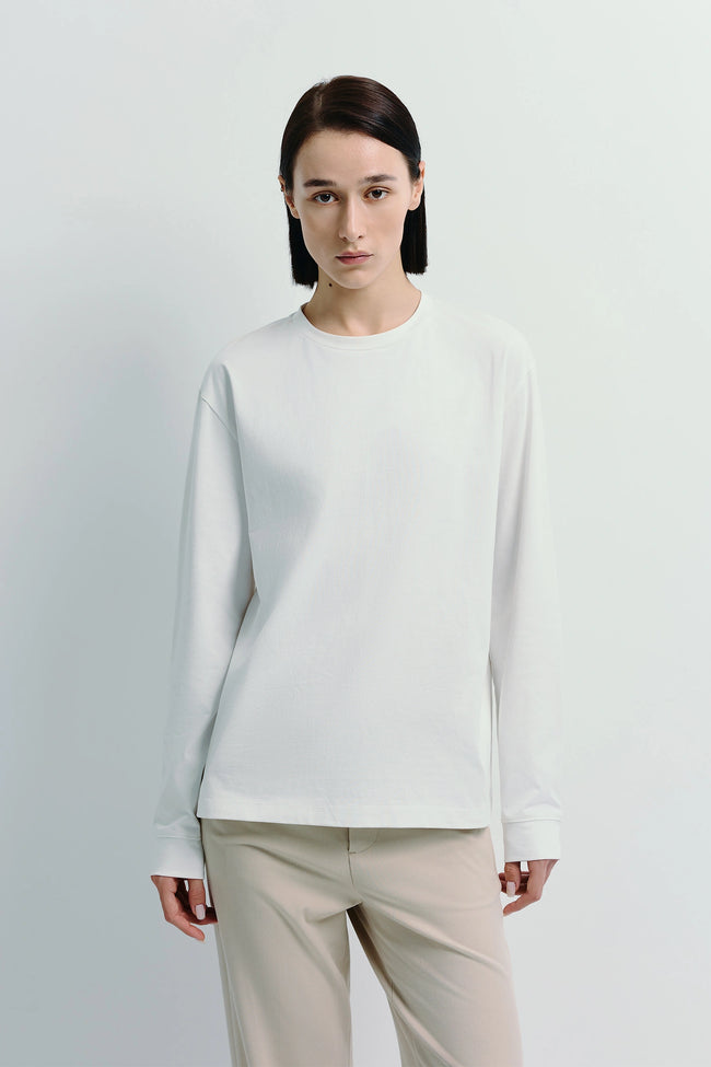 Woman wearing Anza Long Sleeve Top, a white crewneck, regular-fit top made from cotton-polyester blend.