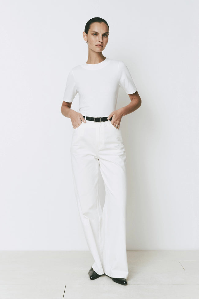 Ruesophie white mid-rise wide leg Galerie Pant with flat front, jean-style pockets, styled on model.