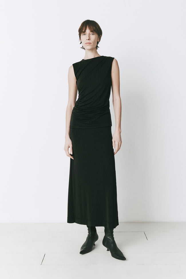 Alizé Modal Knit Skirt in black, styled with matching top and boots, midi length, minimalist fashion