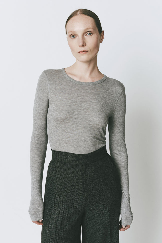 Grey long-sleeve crewneck top in a rayon-acrylic blend on a model.