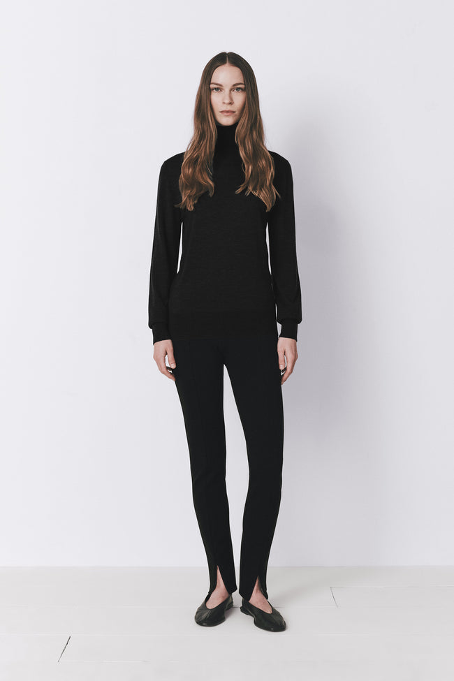 Black Dion wool & silk sweater with matching pants, featuring a turtleneck and split-hem details.