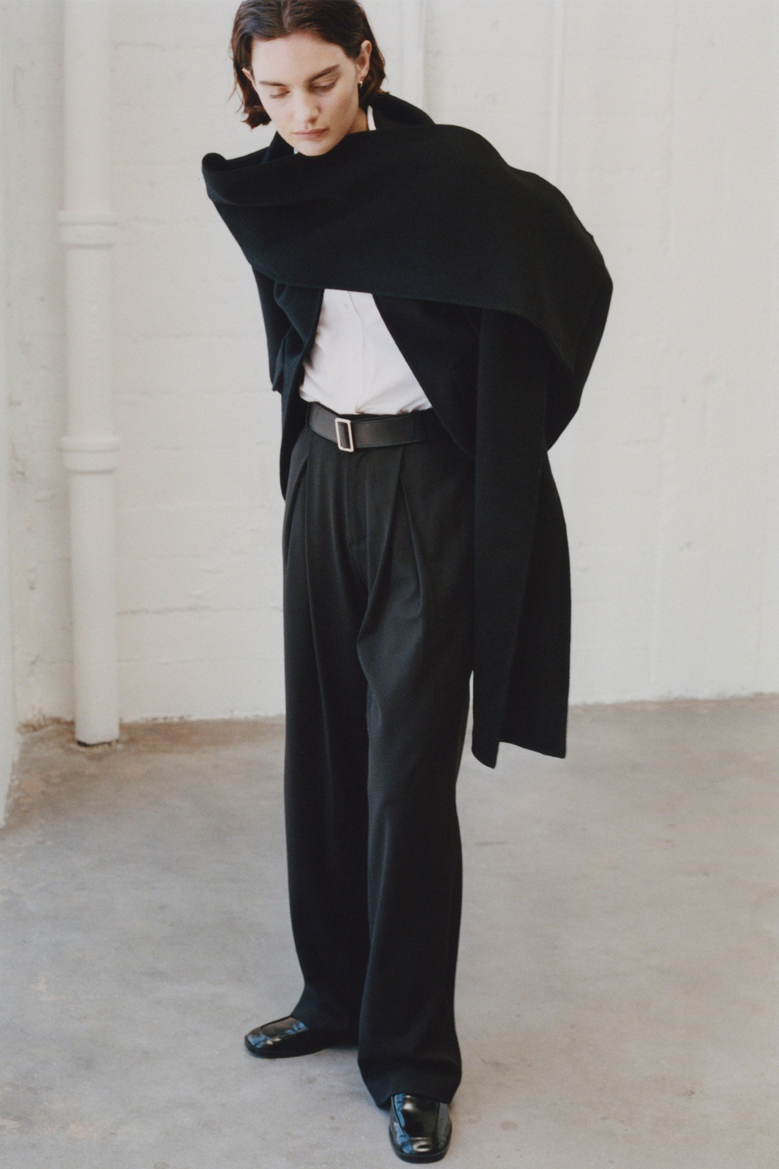 Rue Sophie Jardin black wool coat with scarf detail, woman in minimalist black attire, elegant modern fashion, cashmere blend