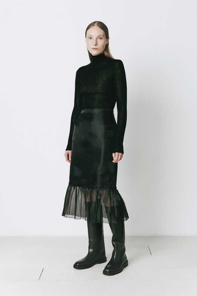 Black midi skirt with organza peplum hem and black boots, perfect for fall ensembles.