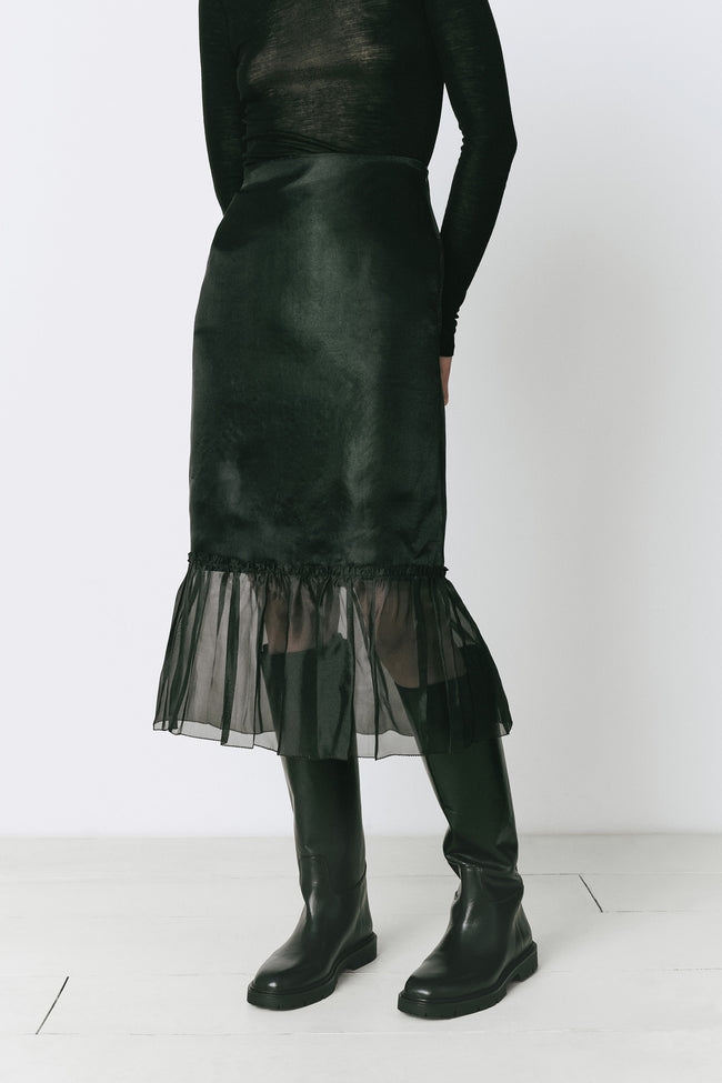 Black midi skirt with organza ruffle detail and black boots, perfect for fall ensembles