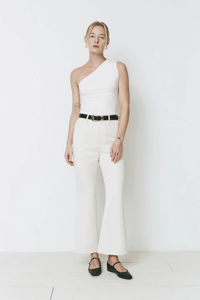 Woman in Gesture Flare Pant wearing a white top and black belt
