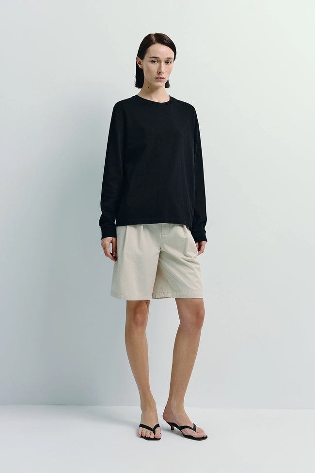 Anza Long Sleeve Top in black, cotton blend, paired with khaki shorts, versatile essential