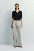 Model wearing Vélo Crinkled Cotton Wide Leg Pants, beige color, paired with a black shirt, showcasing the relaxed fit