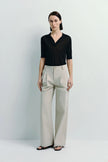 Vélo Crinkled Cotton Wide Leg Pant in beige, paired with a black top. Features pleated front and modern drape.
