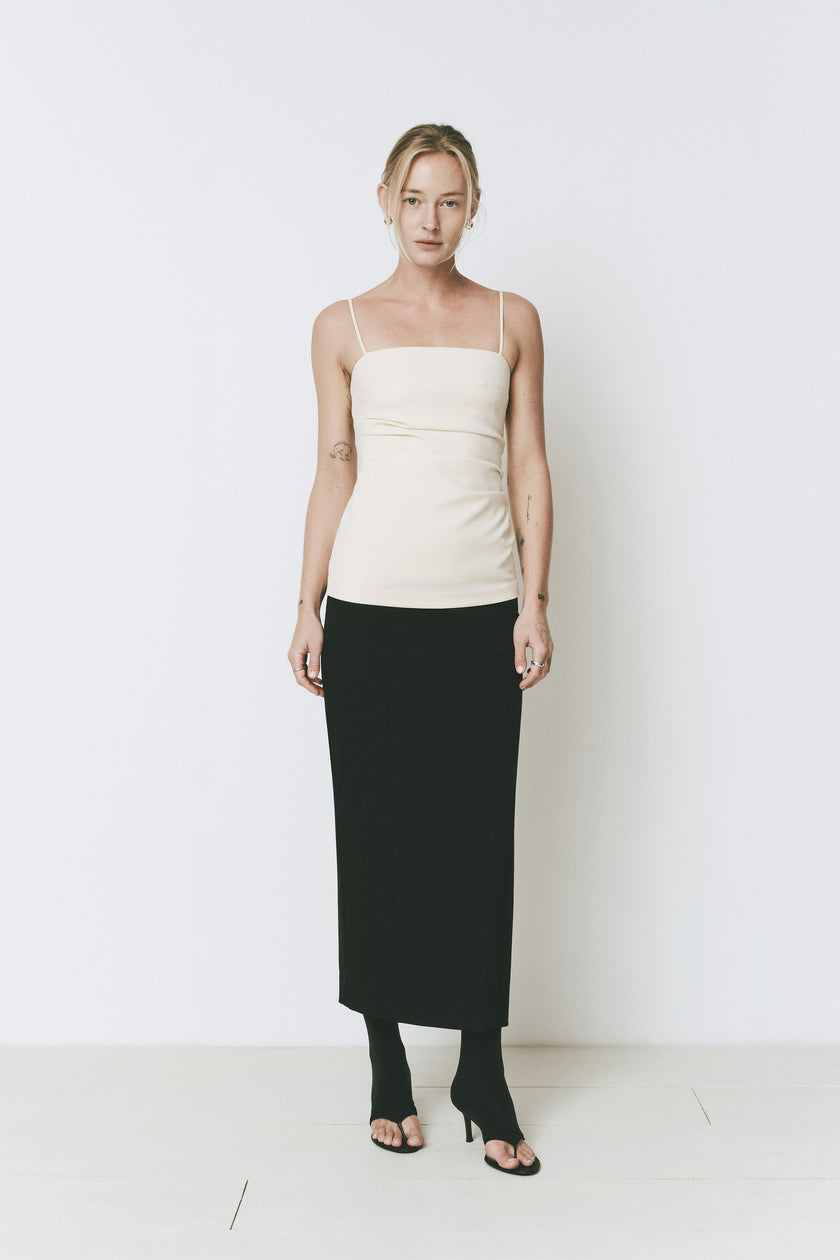 Figaro Skirt product shot: Black midi skirt with cream top. Demonstrating fit and style.