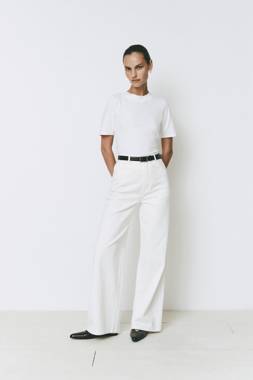 Rue Sophie Chabot Mock Neck Top in white with wide-leg pants, black belt and shoes
