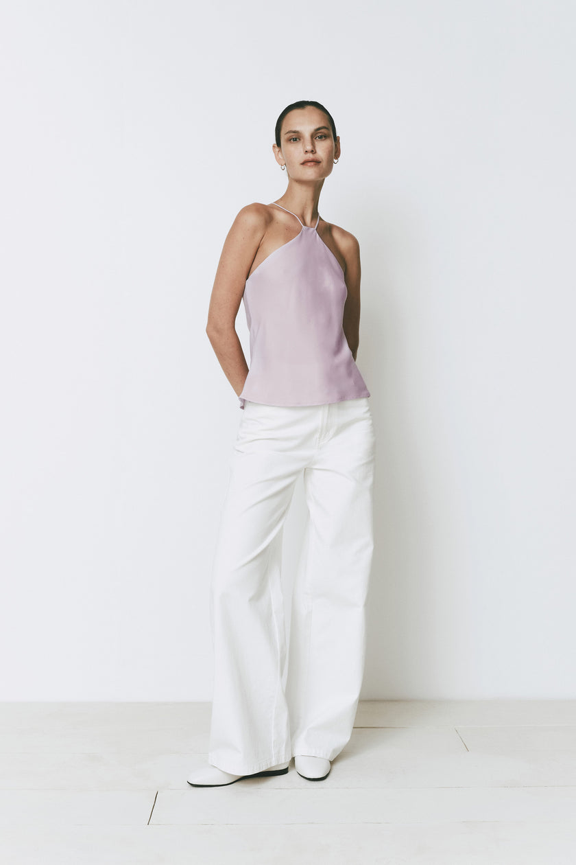 Rue Sophie Arc Top in light purple, halter neck, and white trousers. Minimalist design.