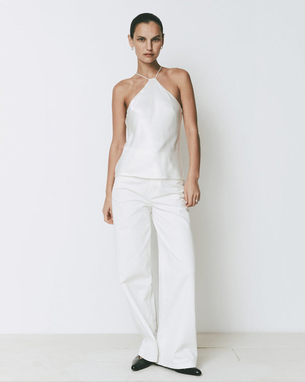 White Arc Top halter neck top, back strap detail and matching white pants. Modern, minimalist style.