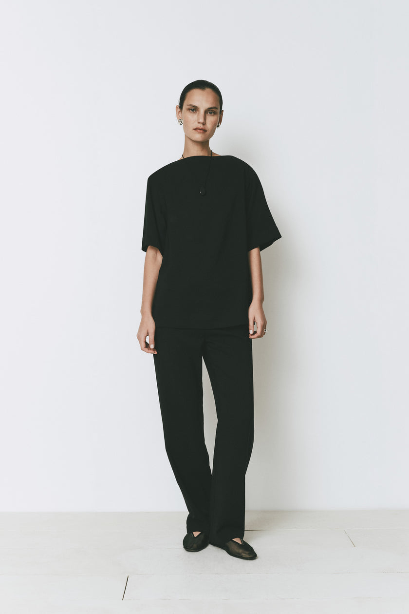 Black Dusk Boatneck Top, high neckline, and matching black trousers. Modern and minimal design by Rue Sophie.