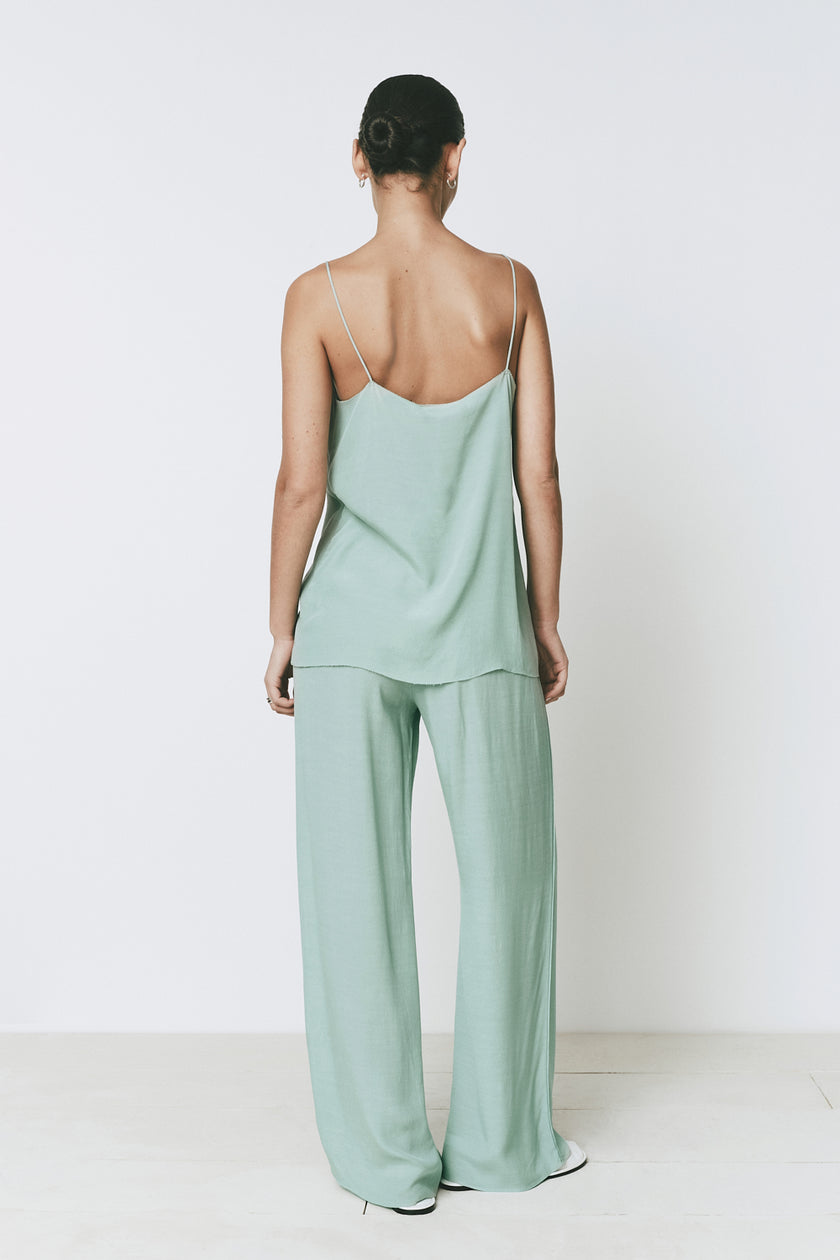 Esme Top in mint green. Model wearing a spaghetti strap top and matching wide-leg pants, back view.