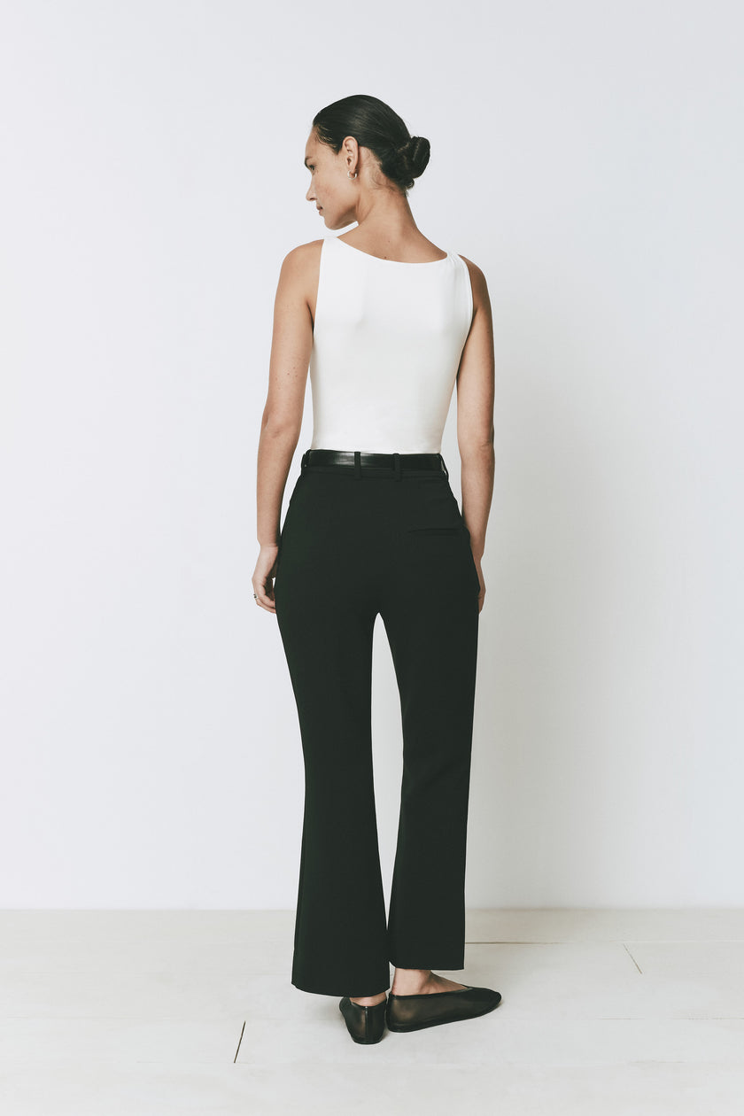 Gesture Flare Pant in black with white top. Modern, tailored fit, black belt detail. Shop Rue Sophie.