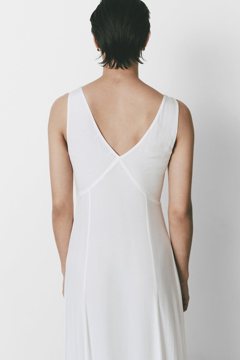 Narbonne Dress in white, back view, showcasing V-neckline and flowing skirt.