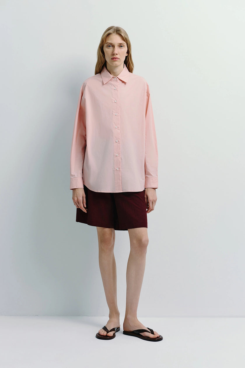 Light pink Alda Button Down Shirt, relaxed fit, paired with maroon shorts, creating a refined style.