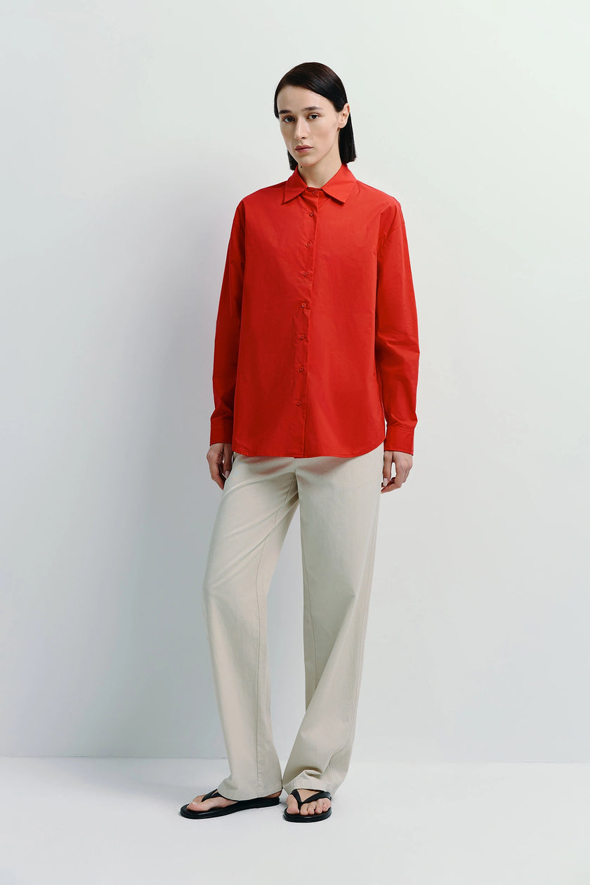 Alda Button Down Shirt in red, 100% cotton, worn with cream pants. Perfect for layering.