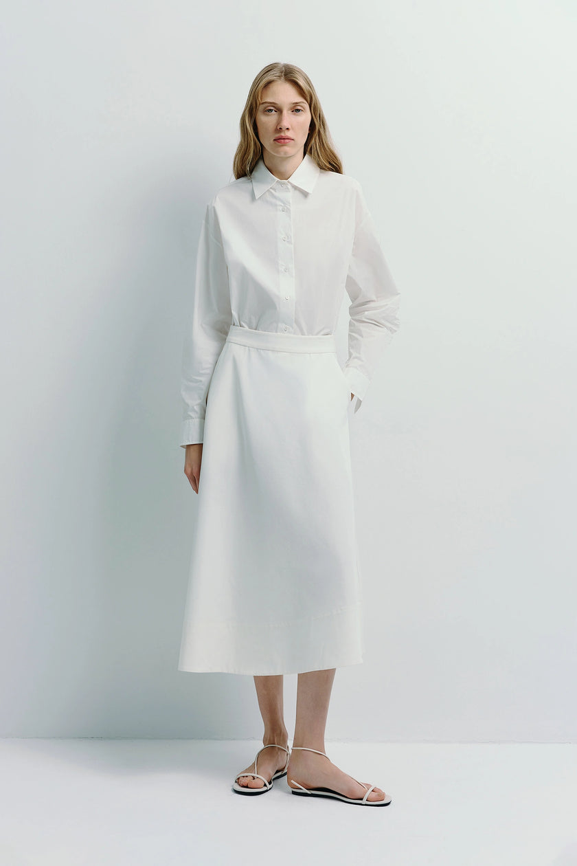 Woman in white cotton Alda button-down shirt and skirt, light luxury aesthetic
