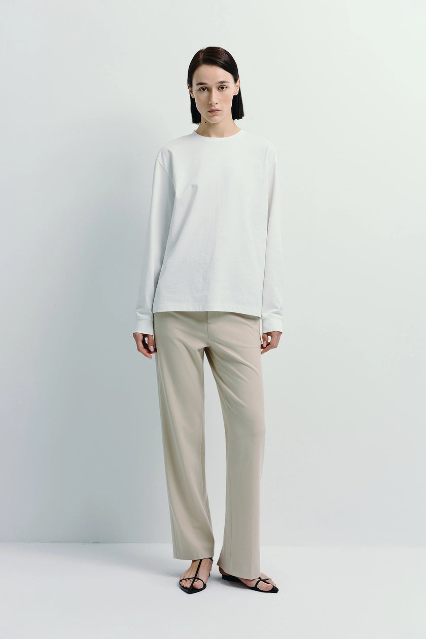 White Anza Long Sleeve Top made from cotton-polyester blend, a minimalist crewneck design, perfect for layering.