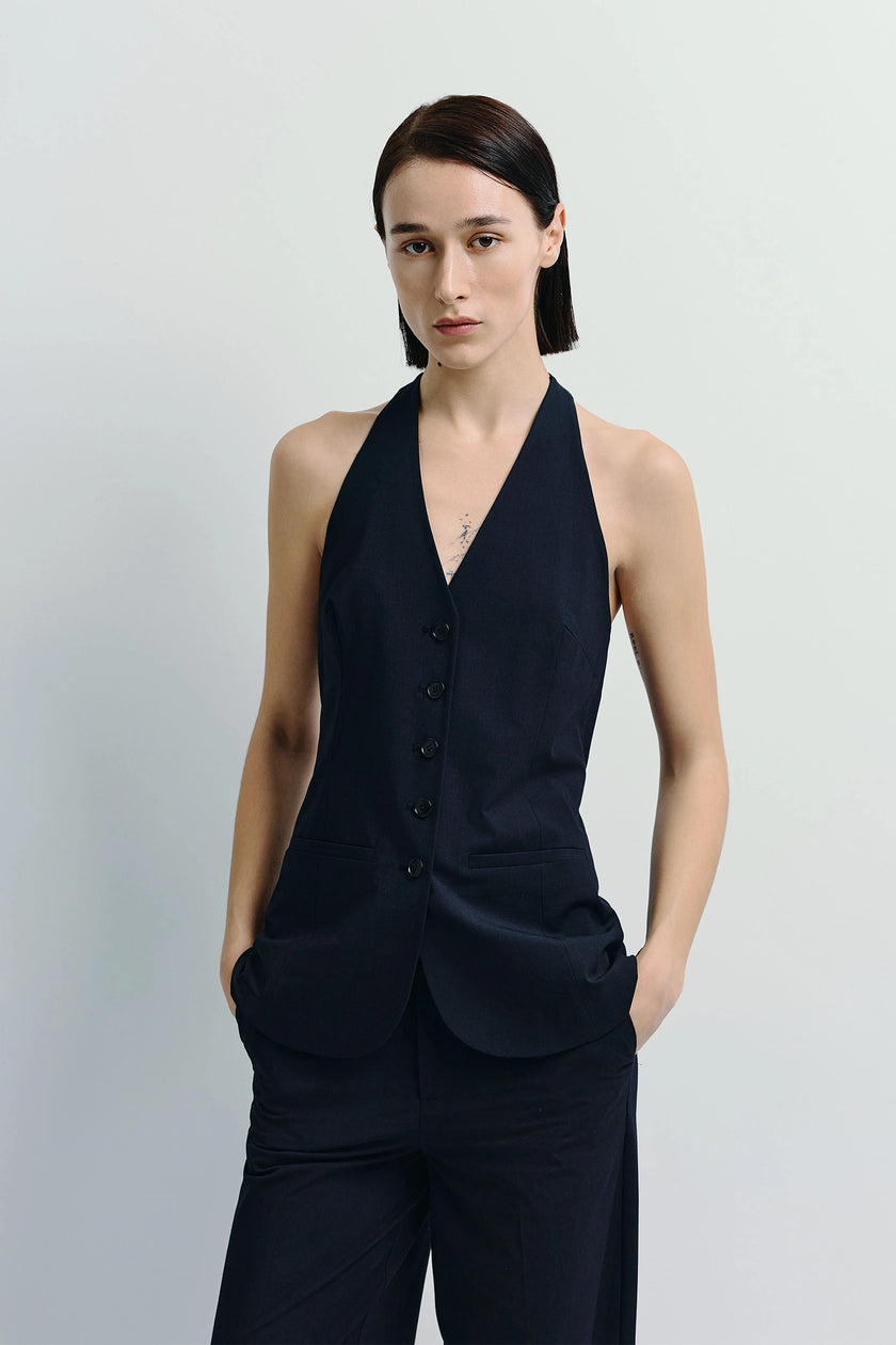 Donette Halter Vest in navy blue, button-front detail, paired with trousers. Modern tailored ensemble.