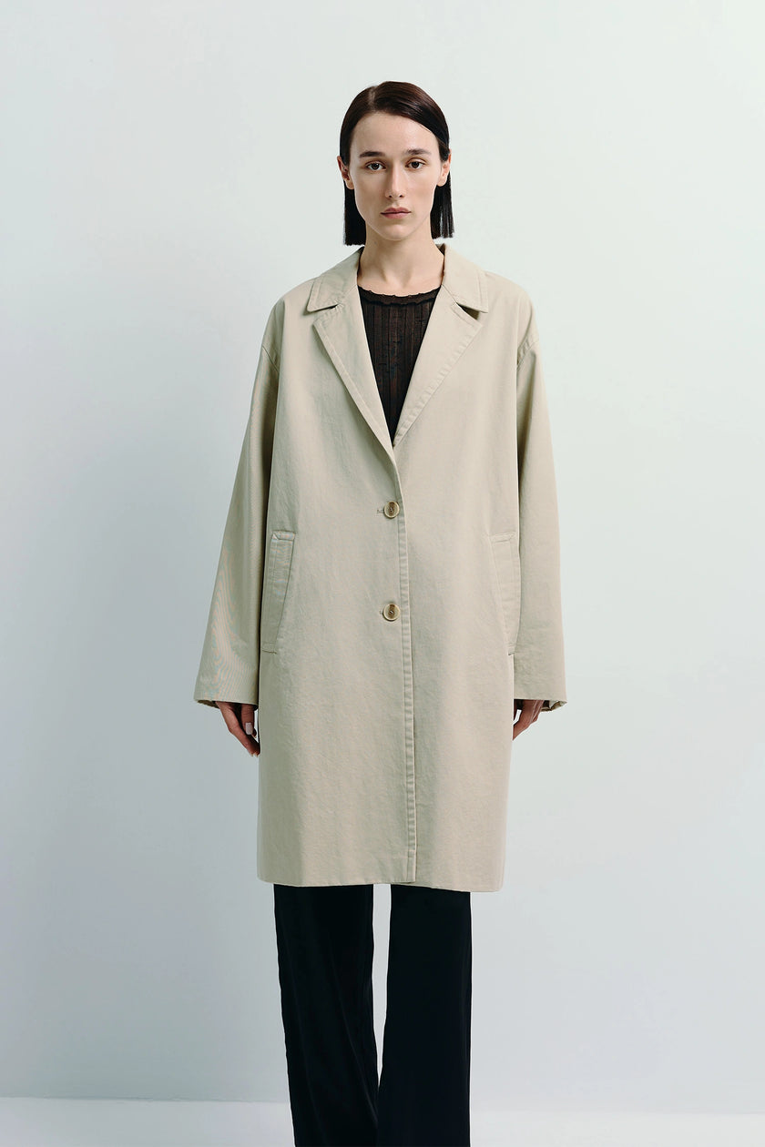 Dune Cotton Twill Coat in light beige, model wearing black outfit. Oversized cotton twill coat.