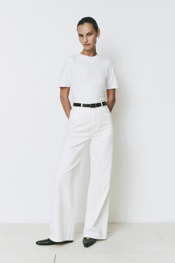 Ruesophie white mid-rise flat front wide leg Galerie Pant on model, styled with a black belt.