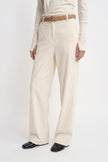 Close-up of Rue Sophie’s Talia Wide Leg Corduroy Pant in Winter White, showing the fine vertical corduroy texture, front fastening, belt loops, and wide-leg cut, styled with a tan leather belt and ivory top.