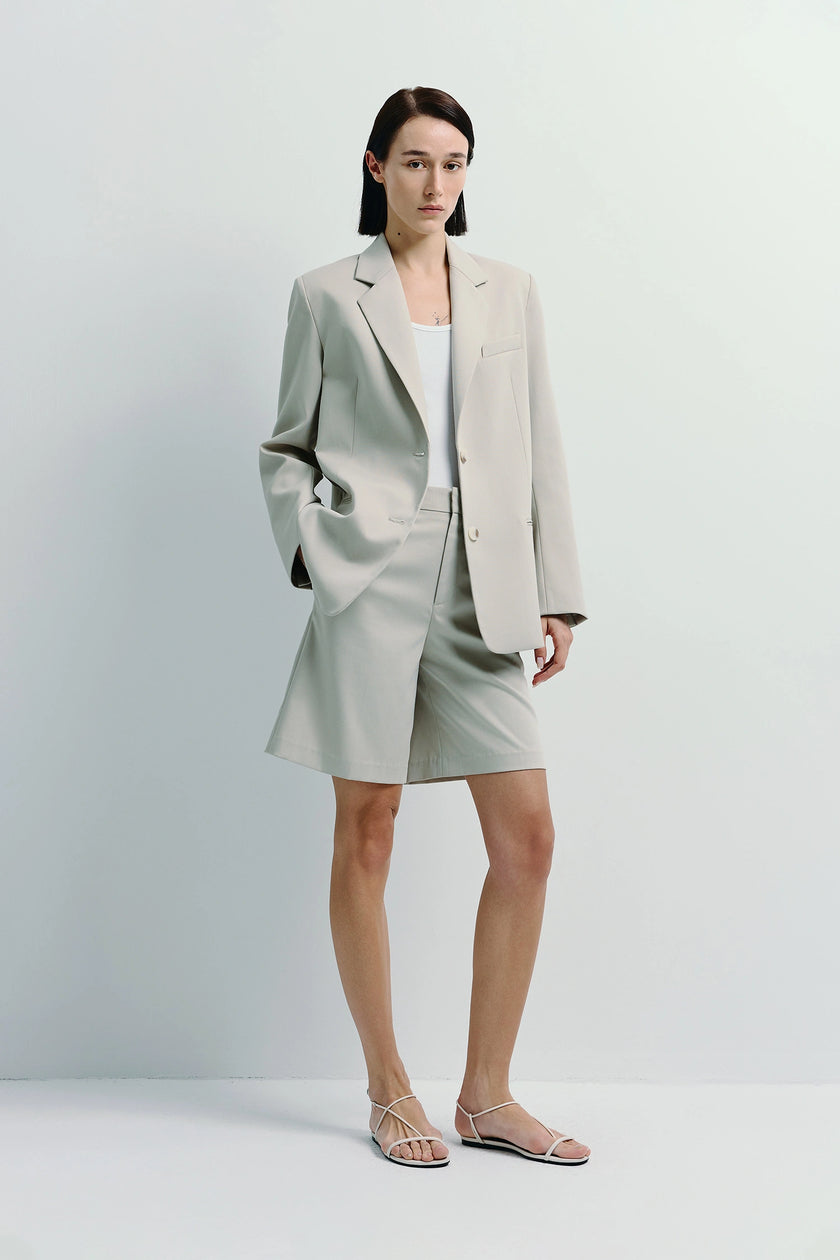 Beige blazer and Lela Bermuda shorts ensemble on a model, perfect for warmer outings