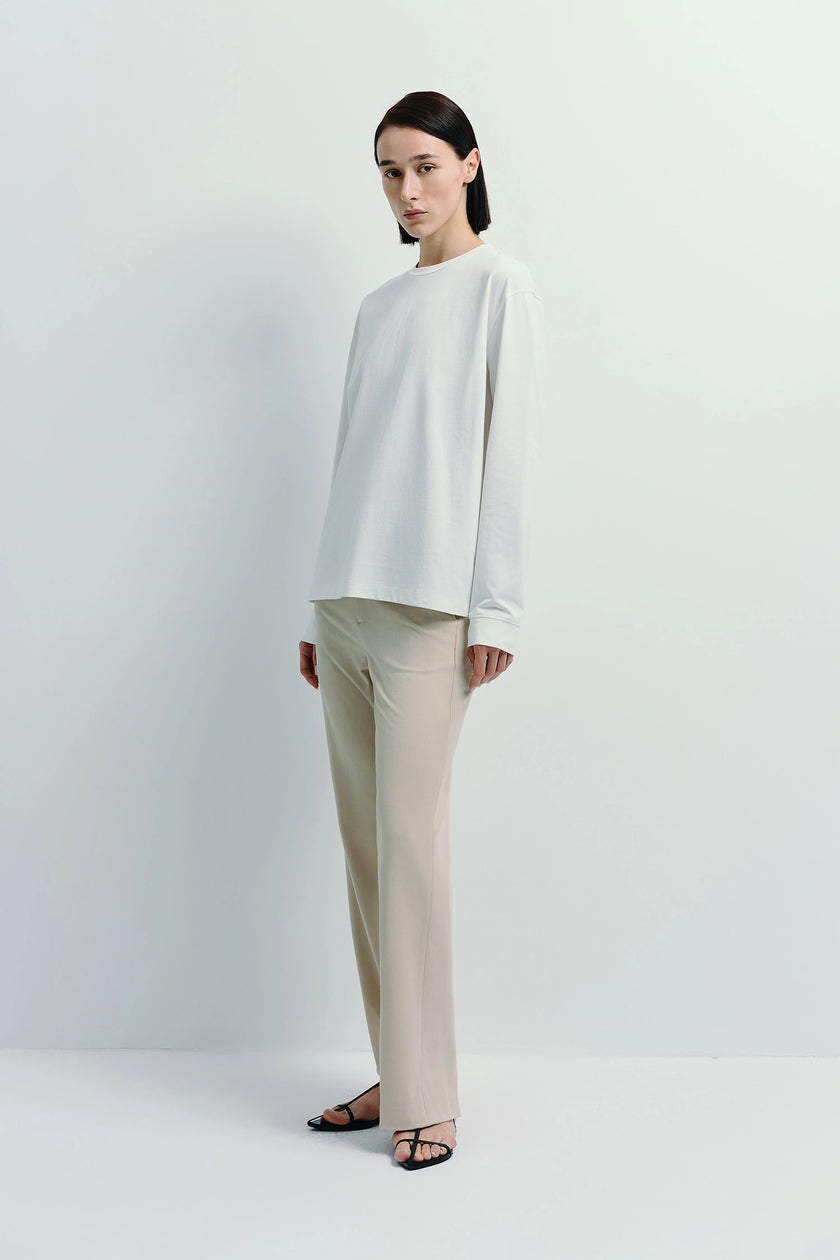 Beige Parker Straight Leg Pants paired with white long-sleeve shirt, cotton-lyocell blend, regular fit.