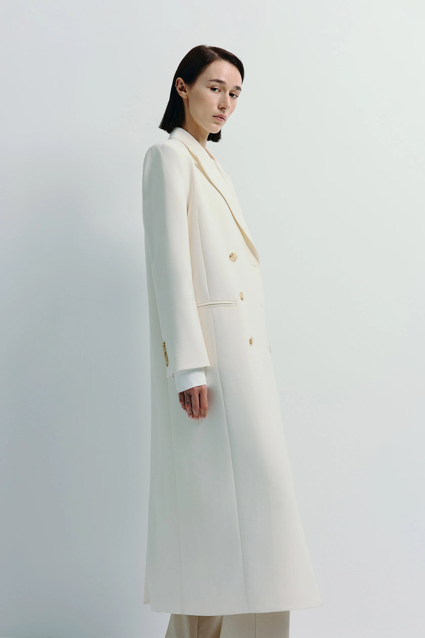 White Remie Double Breast Coat with gold buttons. Midi-length polyester-wool blend outerwear.