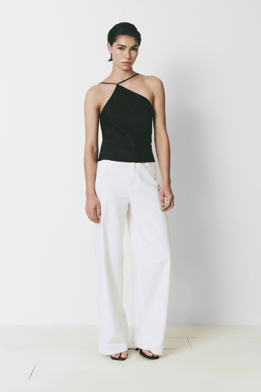 Yvoire Top black halter neck with wide-leg white pants. Slim fit, modern woman's style.