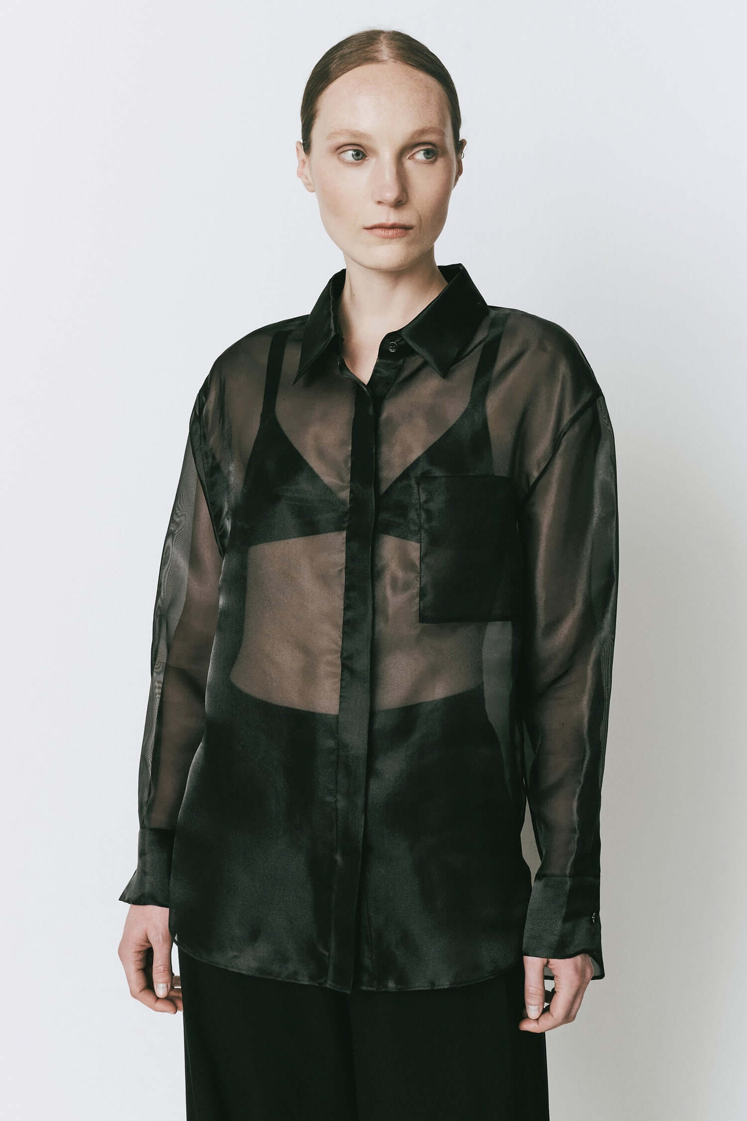 Rue Sophie Auber Organza Shirt in black. Sheer oversized design with hidden front button closure, ideal for chic layering and elegant fashion looks.