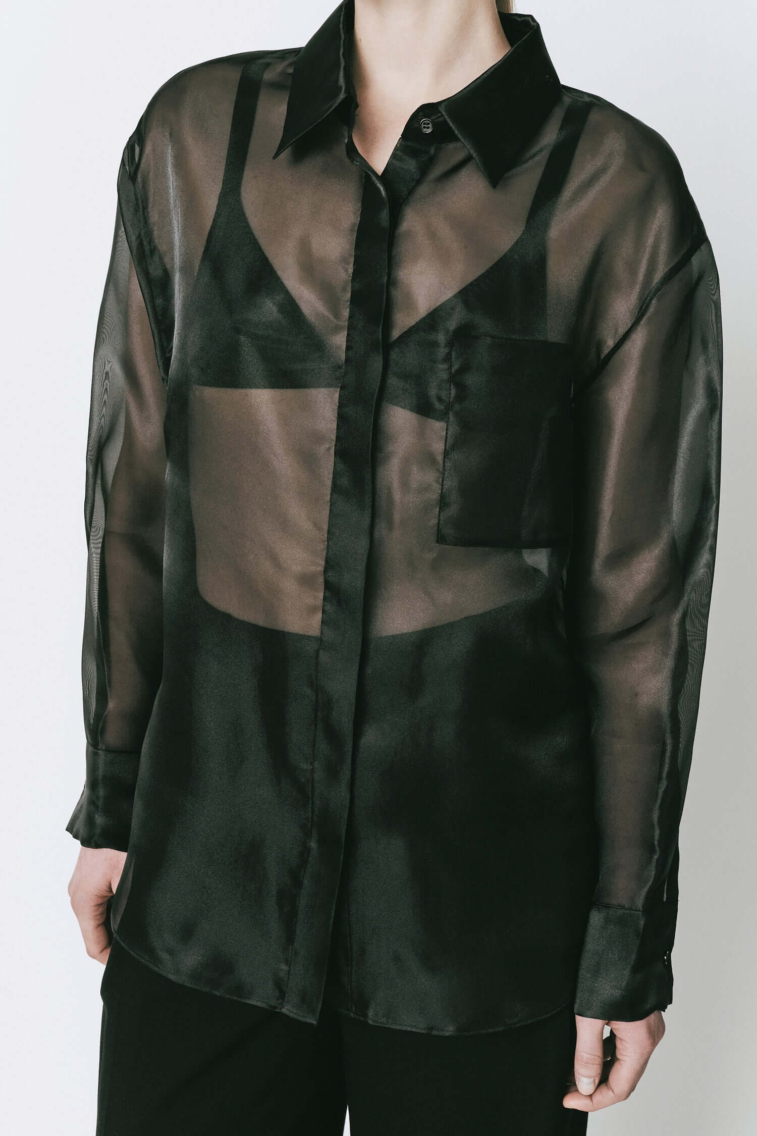 Rue Sophie Auber Organza Shirt in black. Sheer oversized design with hidden front button closure, ideal for chic layering and elegant fashion looks.