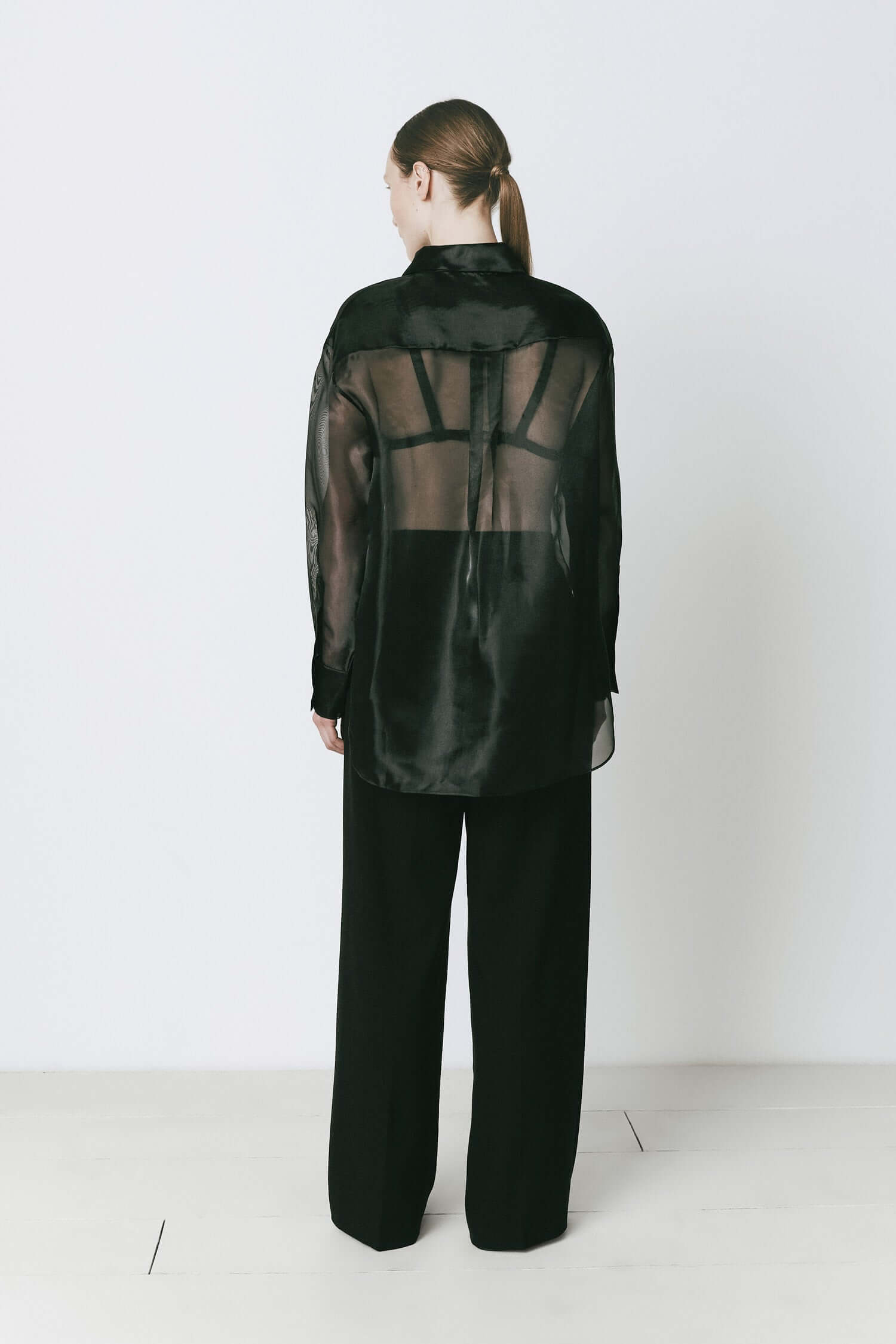 Rue Sophie Auber Organza Shirt in black. Sheer oversized design with hidden front button closure, ideal for chic layering and elegant fashion looks.