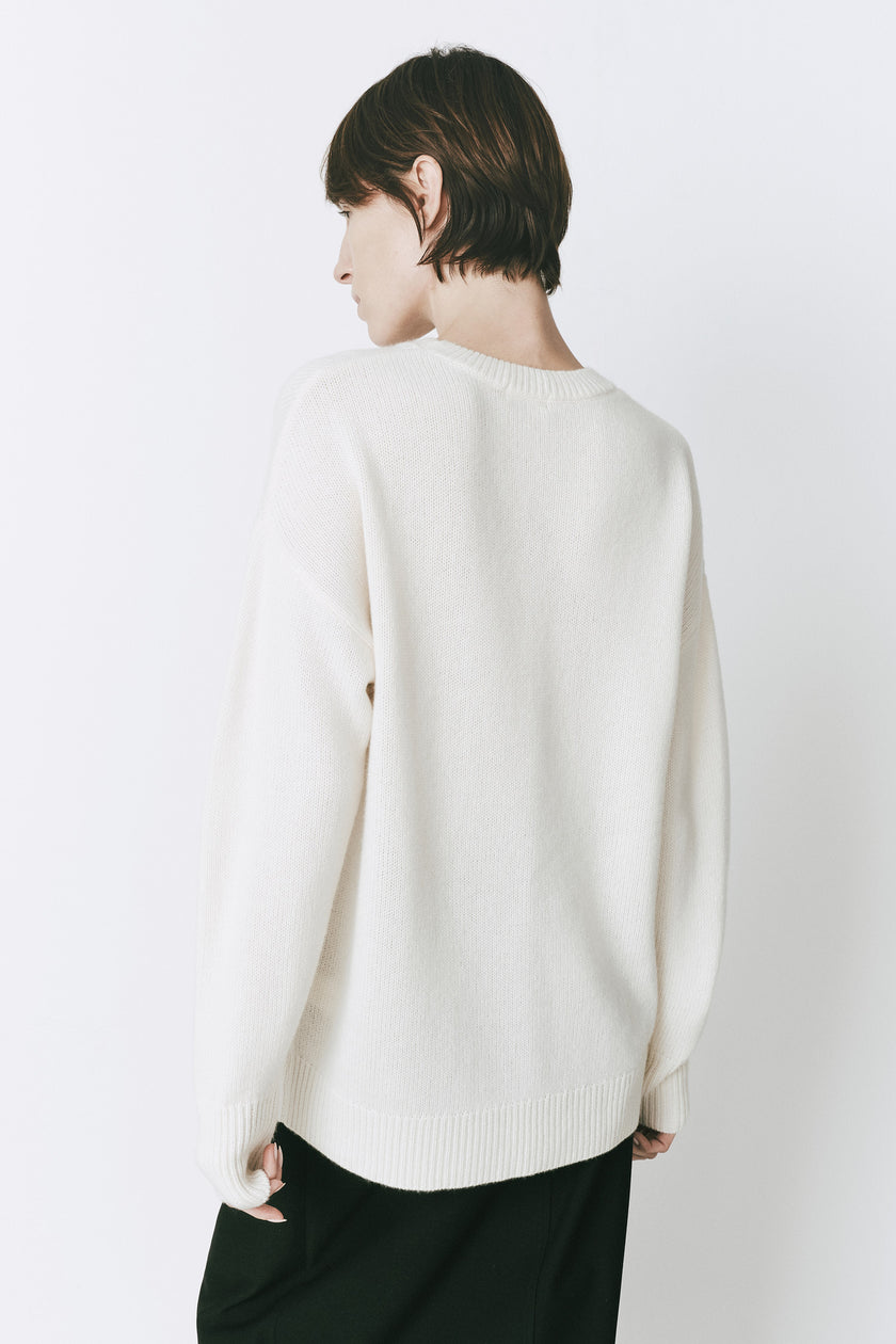 White Boulogne cashmere blend sweater, back view on model, paired with black skirt