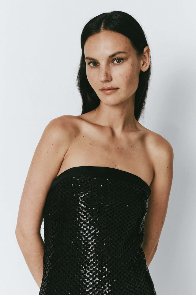 Black sequin crochet mesh dress, perfect for festive events. Featuring intricate details and a strapless design.
