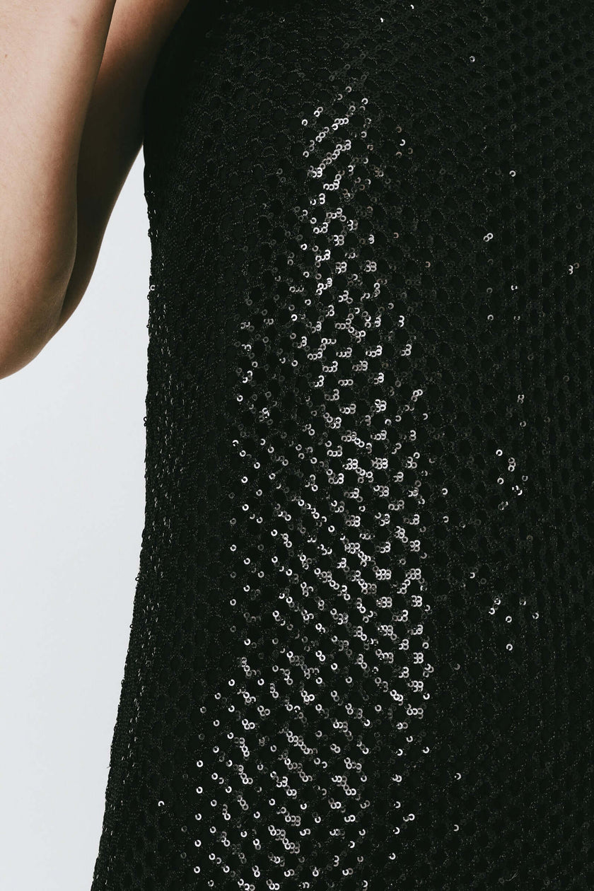 Céleste black sequin crochet mesh dress detail, ideal for festive occasions. Close-up of fabric and sequins.