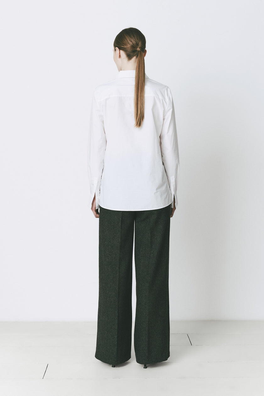 White cotton Charlot button-down shirt with tailored fit, paired with green trousers. A sophisticated look.