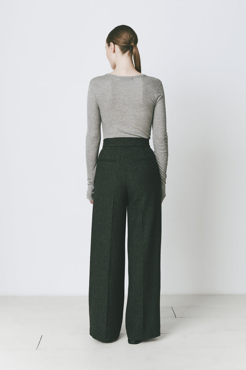 Grey long sleeve top and dark green tailored trousers. Modern layering and minimalist aesthetic.