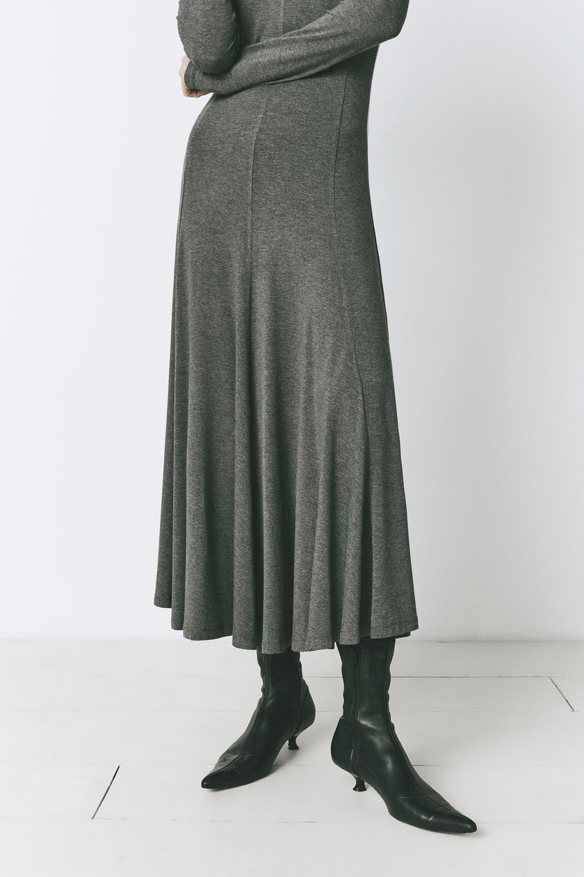 Grey jersey Cler dress with long sleeves and flared skirt, styled with black boots for elegant wear.