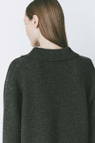 Model wearing a Crémieux wool-blend oversized V-neck sweater in dark charcoal. The cozy ribbed texture and relaxed fit add warmth and style, making it a versatile choice for casual and professional outfits.