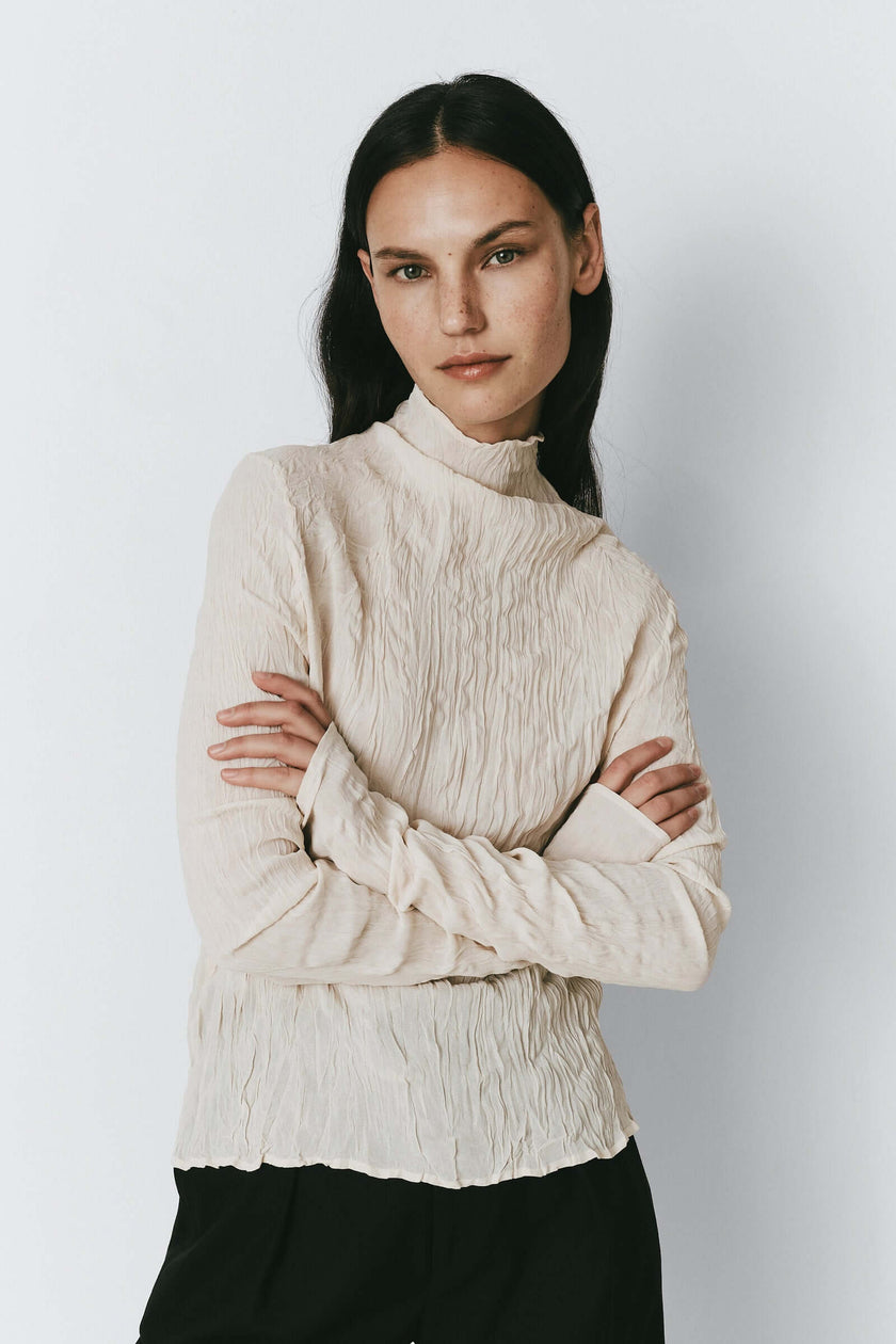 Ivory crinkled top for women. Viscose mock neck shirt for a light luxury aesthetic.