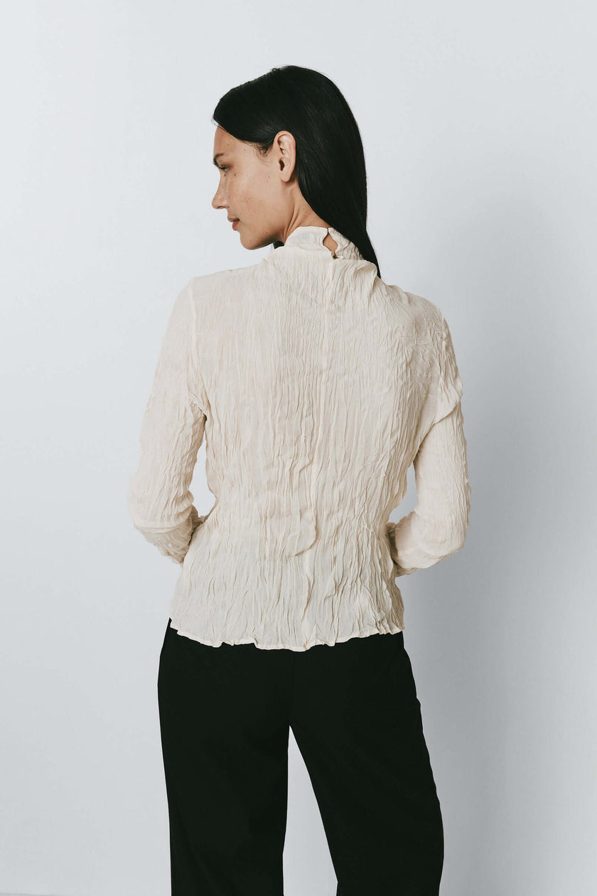Ivory crinkled viscose Degaré top with black trousers
