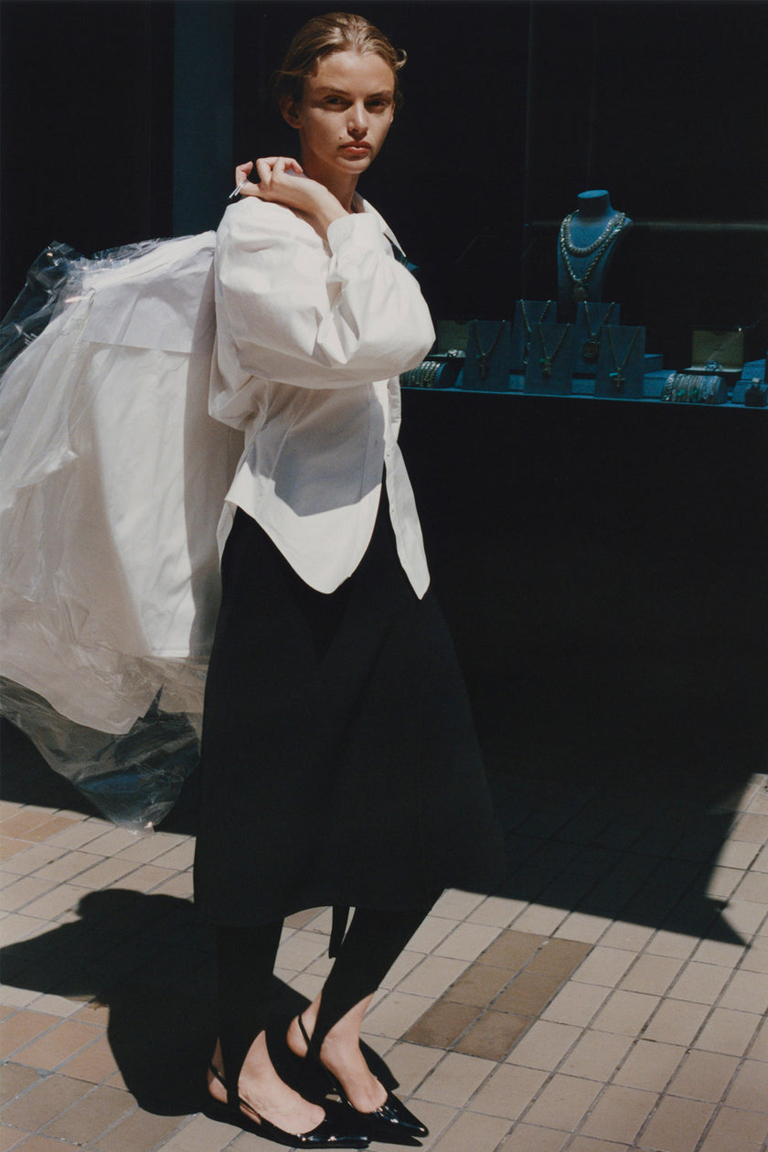 White cotton Fontaine balloon sleeve shirt, black skirt, and leggings, stylish outfit