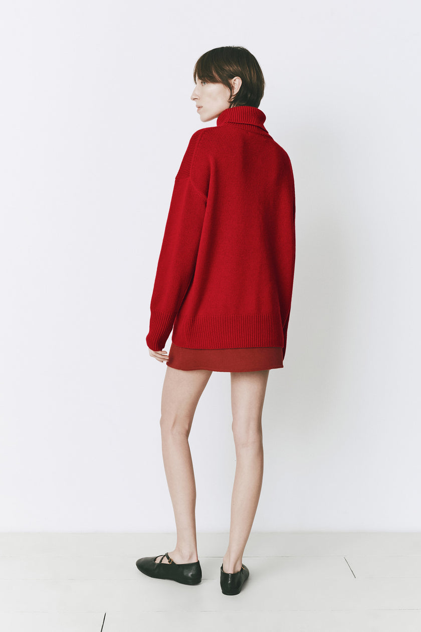 Rouge red wool-cashmere blend Garches Turtleneck Sweater, loose fit, paired with a red skirt.