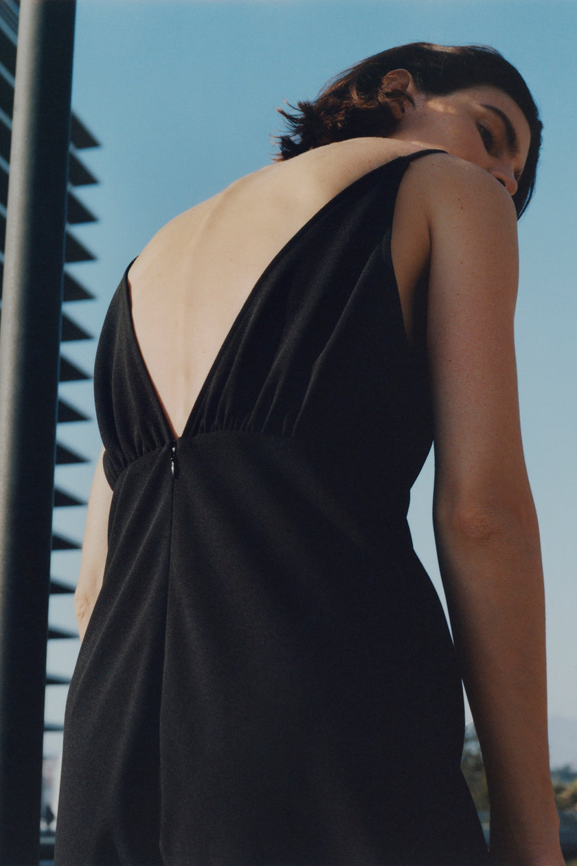 Black Liana Notch V-Neck Dress in polyester-spandex blend, showing back with deep V-neck design